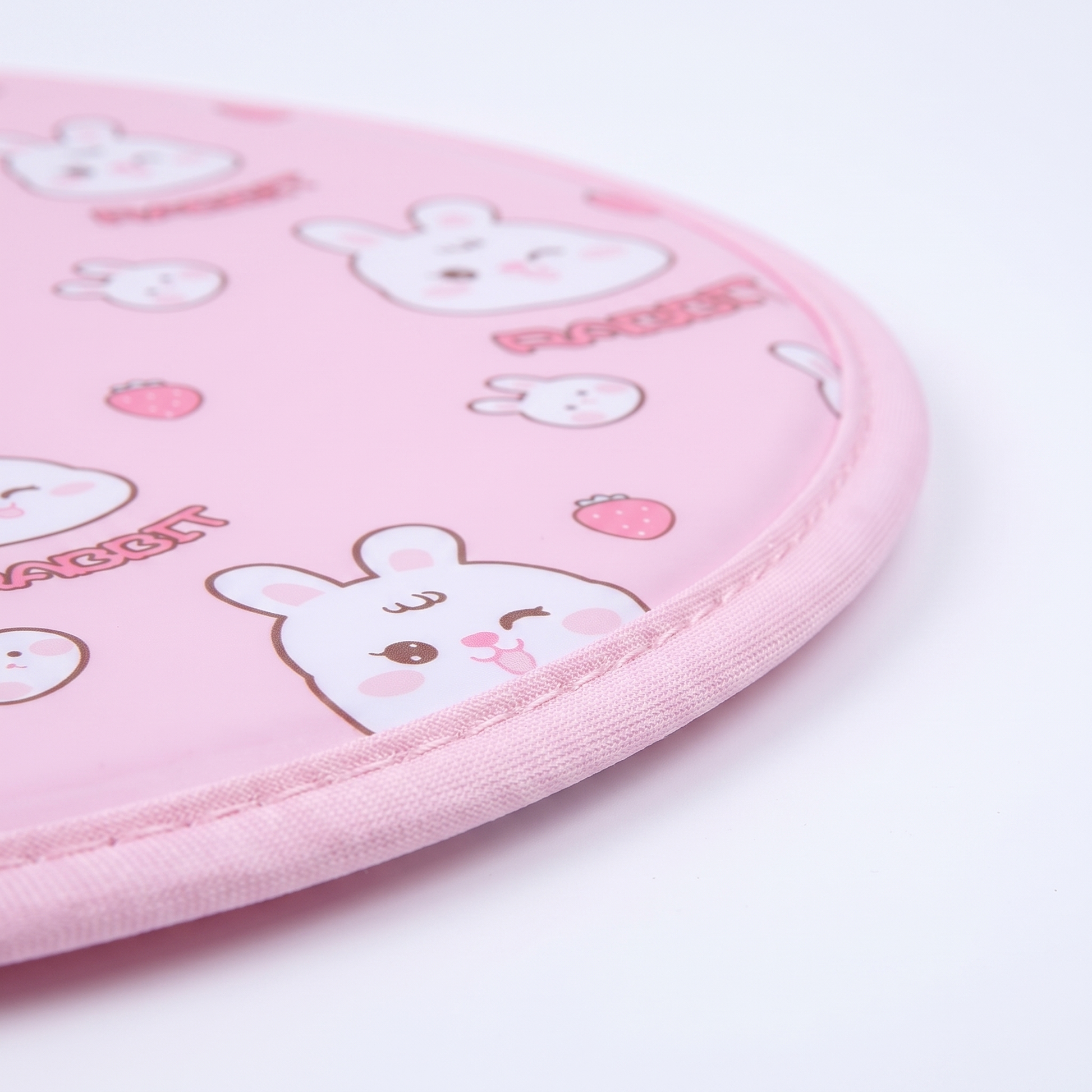 Snaggoo cat cooling gel mat close-up, piped fabric edge and cool-gel surface with rabbit and strawberry print